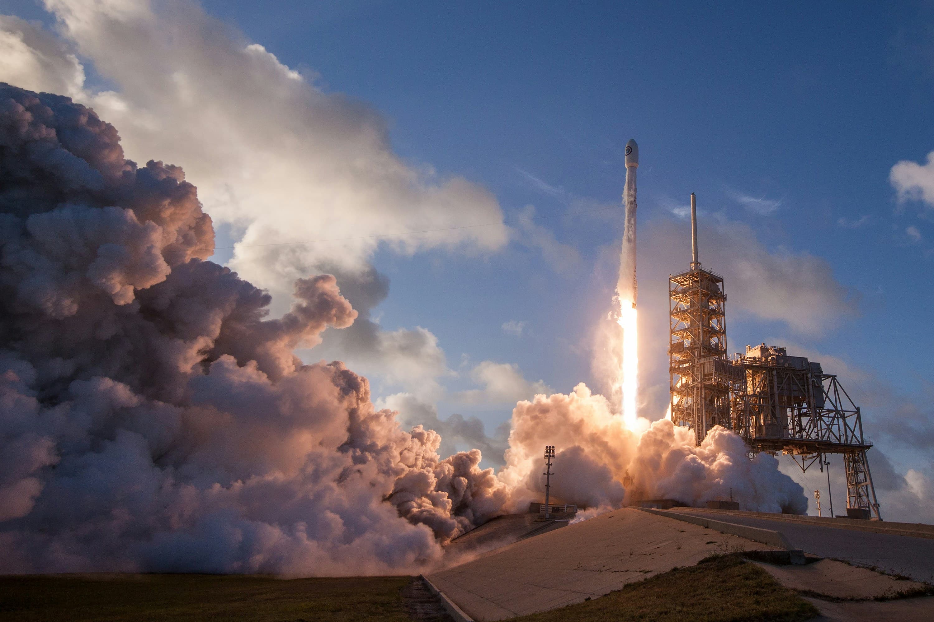 SpaceX Falcon 9 at liftoff with exhaust plume and launch tower